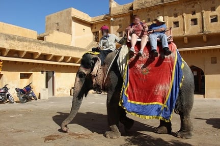 An elephant at Amer Fort with tourists on their back
